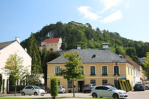 Pitten, Häuserensemble am Hauptplatz, im Hintergrund die Bergkriche und die Burg Pitten