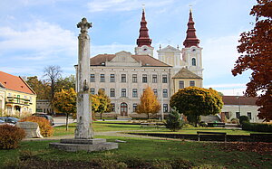 Wullersdorf, Blick über den Hauptplatz, vor der Pfarrkirche das ehem. Rathaus (Benefiziatenstöckl), daneben die ehem. Schule, 1898 errichtet