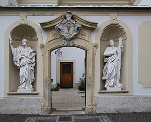 Schwechat, Pfarrkirche hl. Jakobus der Ältere, 1755-56 durch Johann Georg Ebruster errichtet,  Ehrenhof, Portal zum Pfarrhof