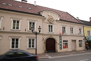 Stockerau, Hauptstraße Nr. 26: Schaumann-Haus, Steinportal bezeichnet 1756, im Ziergiebel Darstellung der hl. Dreifaltigkeit